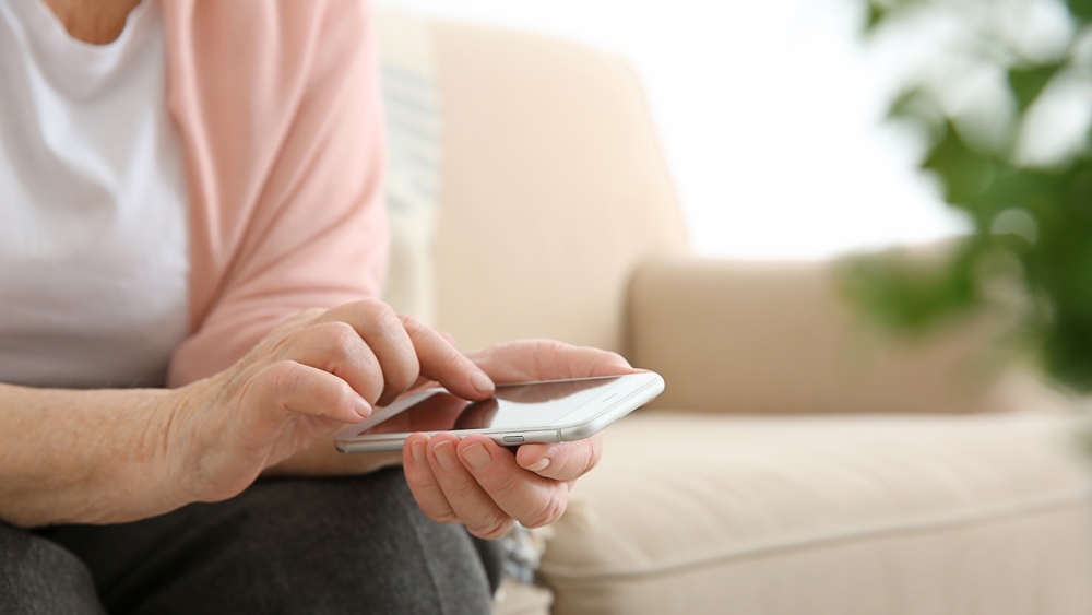 wellspect-elderly-woman-using-smartphone